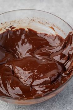 a glass bowl filled with melted chocolate on top of a table