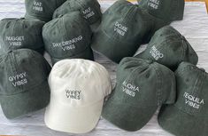 six hats with different types of writing on them sitting on a table top next to each other