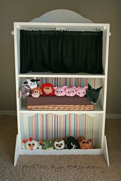 a white book shelf with stuffed animals on it