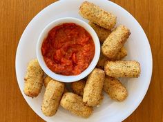 a white plate topped with tater tots covered in tomato sauce