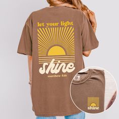 Retro Christian Shirt Let your Light Shine Matthew 5:16 Shirt Trendy Christian Tee Faith Based Tshirt Comfort Colors Christian Gift Idea This Comfort Colors tshirt features a large back graphic of a setting sun and the Bible verse Matthew 5:16 "Let your light shine." The front of the shirt features the same sun graphic with the word "shine."  There is a matching youth shirt here: https://withawildflowerllc.etsy.com/listing/1777405876 ✿ The With A Wildflower mission is to give God the glory and g Sun Graphic, Matthew 5, Comfort Colors Tshirt, Youth Shirt, Let Your Light Shine, Christian Tees, Setting Sun, Christian Shirt, Comfort Colors Tee