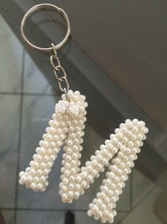 two key chains with pearls attached to them