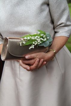 a woman holding a purse with flowers in it