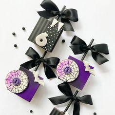 three purple and black decorated items on top of each other, with ribbons around them