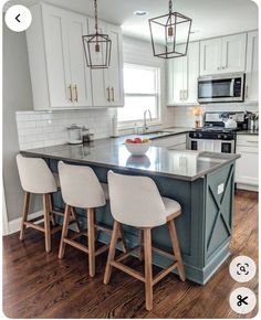 a kitchen island with four stools in front of it