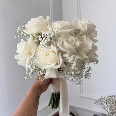 a person holding a bouquet of white flowers