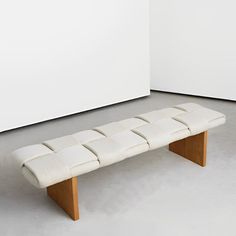 a white bench sitting on top of a cement floor