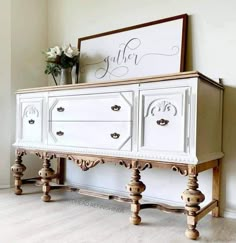 a white dresser with two drawers and a sign above it