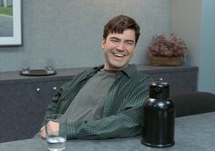 a man sitting at a table with a wine bottle