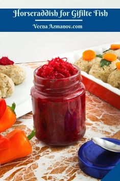 a jar filled with red food sitting on top of a table next to other foods