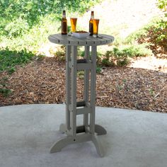 an outdoor table with two bottles of beer on it