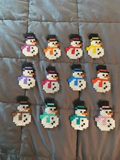 cross stitch snowmen are displayed on a quilt