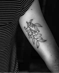 a black and white photo of a woman's arm with a tattoo on it