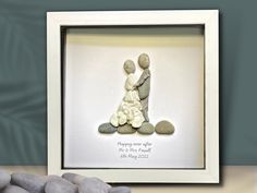 there is a framed picture with two rocks and a small rock in front of it