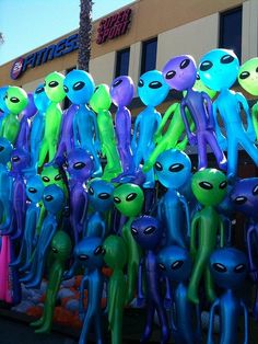 there are many alien balloons in front of the building