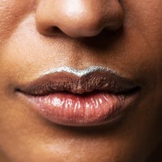 a woman's lips and nose are shown with silver foil on the tip of her lip