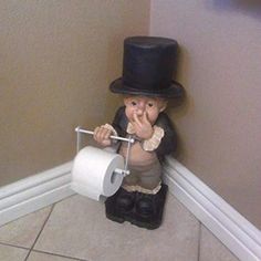 a statue of a boy with a top hat and cane holding a roll of toilet paper