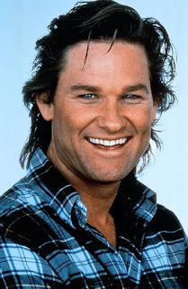 a close up of a person wearing a plaid shirt and smiling at the camera with long hair