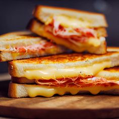 three grilled cheese sandwiches stacked on top of each other with melted cheese and meat