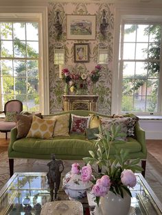 a living room filled with lots of furniture and flowers on top of a coffee table