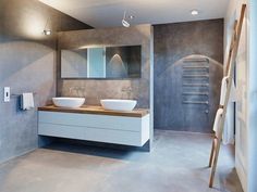 a modern bathroom with two sinks and mirrors