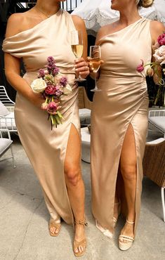 two women standing next to each other holding wine glasses