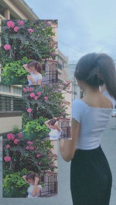 a woman standing in front of a building while talking on a cell phone and looking at flowers