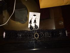 a pair of black earrings sitting on top of a table next to a package of jewelry