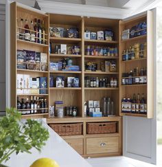 an organized pantry with wooden shelves and wicker baskets on the bottom shelf is shown