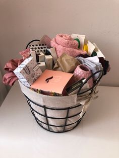 a basket filled with lots of items sitting on top of a white table next to a wall