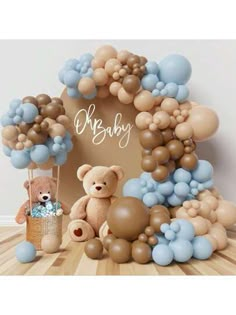 a teddy bear surrounded by balloons and other items for a baby's first birthday