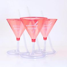 three pink wine glasses sitting on top of each other in front of a white background