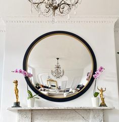 a living room with a fire place and a mirror on the fireplace mantel above it