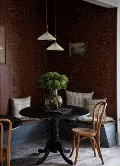 a dining room table with two chairs and a potted plant on top of it