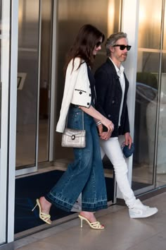 a man and woman walking out of an elevator