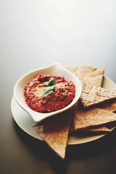 a white plate topped with tortilla chips and salsa