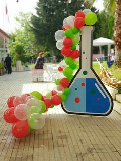 a bunch of balloons that are in the shape of a science beakle on a sidewalk