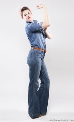 a woman is posing with her arms up in the air while wearing jeans and a bandana