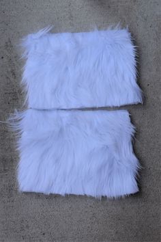 two pieces of white fur laying on the ground