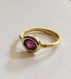 This rhodolite garnet and nine ct yellow gold ring is handmade and one of a kind. It's perfectly imperfect rustic style is warm and tactile with bohemian style charm . Gem size 5mmx7mm faceted stone is a lovely wine coloured purple red . Hand Forged Ruby Ring, Handmade Tourmaline Gold Ring, Handmade Gold Tourmaline Ring, Gold Garnet Ring, Talisman Necklace, Garnet And Gold, Etsy Gold Ring, Garnet Ring, Rhodolite Garnet