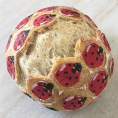 a ball made out of bread with red ladybugs on the inside and black spots