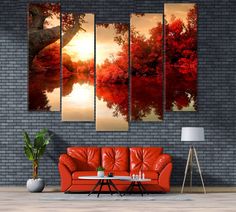 a living room with red couches and paintings on the wall above it, along with a coffee table