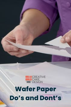 a person cutting paper on top of a table with scissors and other items in front of them