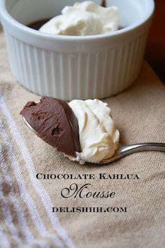 a spoon with some ice cream on it next to a bowl full of whipped cream