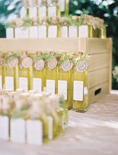 several bottles of olive oil on a table with tags attached to the bottles and labels for each bottle