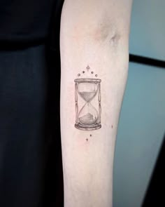 a small hourglass tattoo on the arm