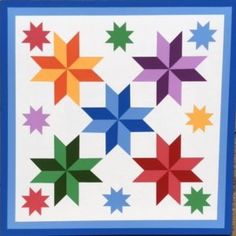 a multicolored star quilt hanging on a wall in front of a brick wall