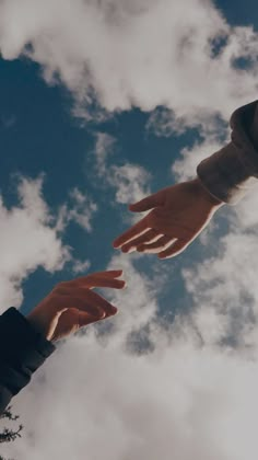 two hands reaching for each other in the sky