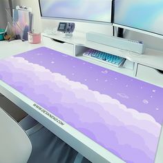 a computer desk with a purple sky and clouds on it