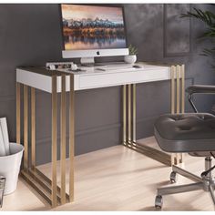 a desk with a computer on it and a chair in front of it, next to a potted plant